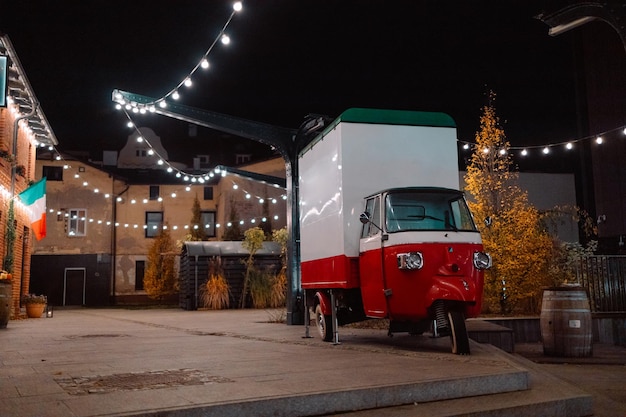 Antique bead car in the color of the italian flag near the city street cafe at night high quality ph