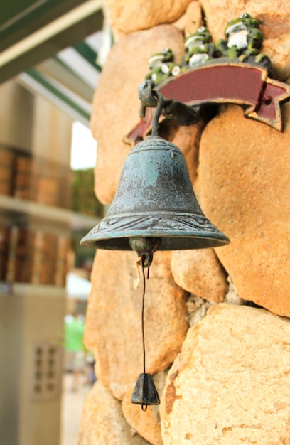 Antique bell hanging on stone wall