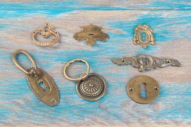 Antique brass key hole covers on wooden background. Copy space for text.