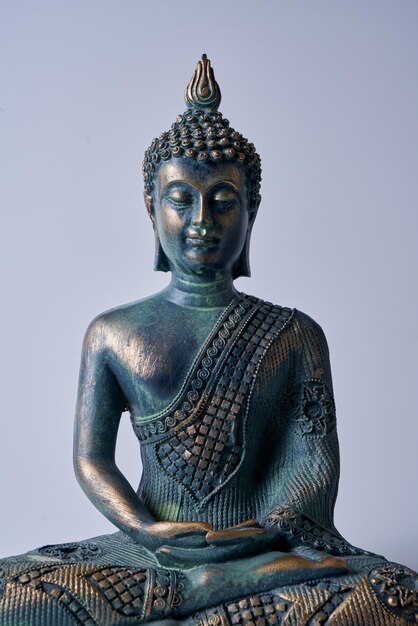 Античная бронзовая статуя Будды на белом изолированном фоне.