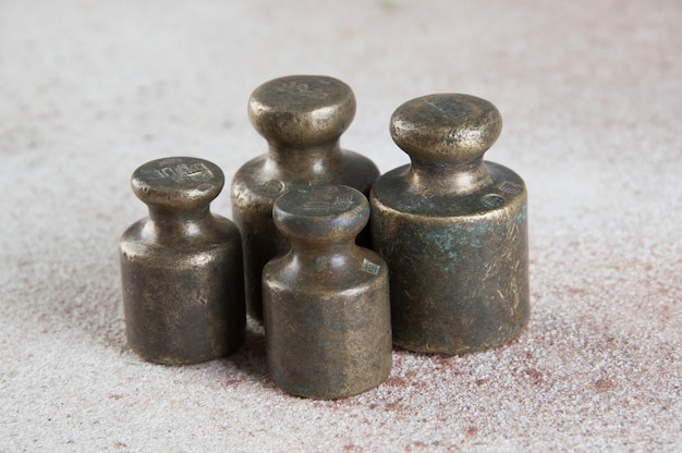 Antique bronze weights for scales on concrete surface