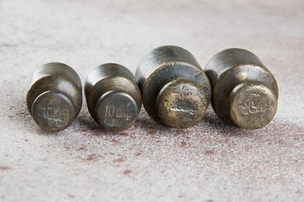 Antique bronze weights for scales on concrete surface