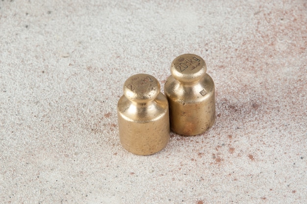 Antique bronze weights for scales on concrete table.