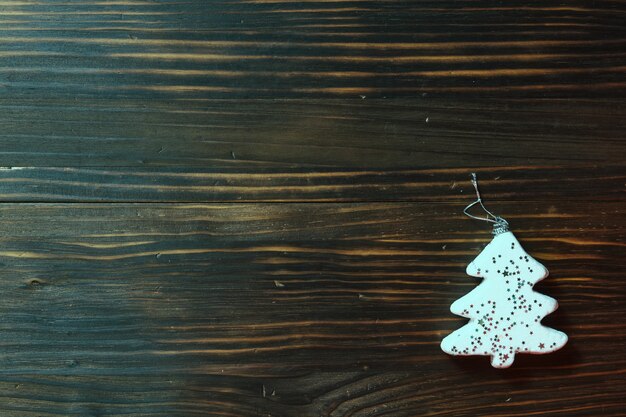 Fondo di legno marrone antico con ornamento di natale a forma di pino bianco nell'angolo in basso a destra dall'alto