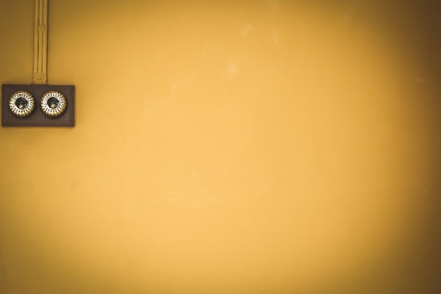 Foto interruttore della luce antico sulla parete di colore giallo inst sullo sfondo della casa d'epoca