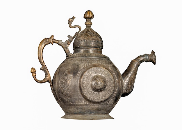 An antique metal teapot with artistic chasing and engraving on\
a white background