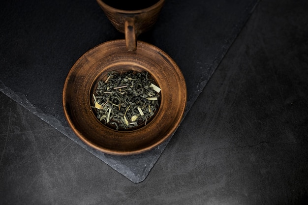 Antique plate with tea on dark background Top view Tea ceremony