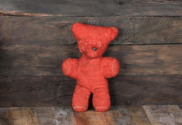 antique red toy bear on old wooden background