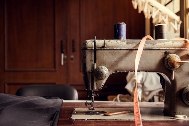 Antique sewing machine on the old wooden table in the old tailor shop