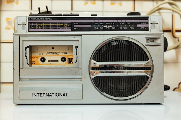 Antique silver colored cassette radio with a tape inside. Vintage Millennial childhood. 80s and 90s.