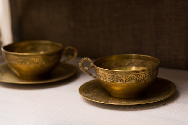 Antiche tazze da tè con piattini in rame. oggetti insoliti per la casa