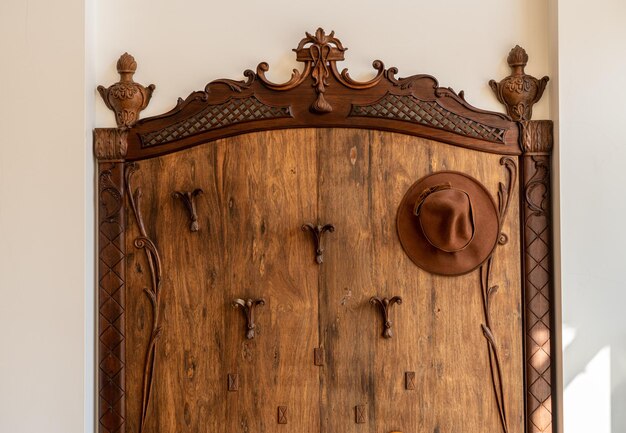 Antique wooden hat and umbrella stand in modern hallway