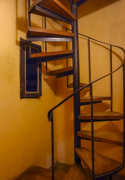 Antique wooden spiral staircase in a corner