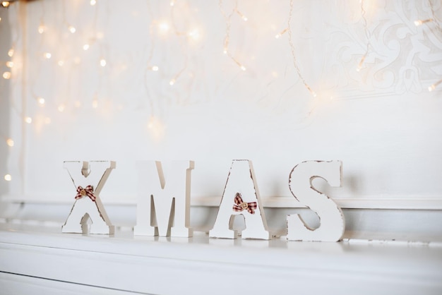 Antique Wooden Word quotXmasquot Stands on White Piano Christmas Decorations in Rustic Style