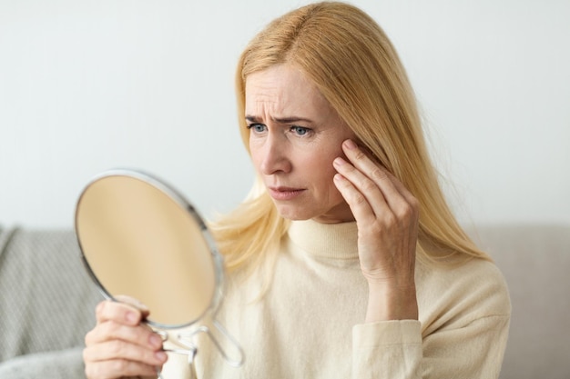Antirimpel Huidverzorging Trieste vrouw die in de spiegel kijkt