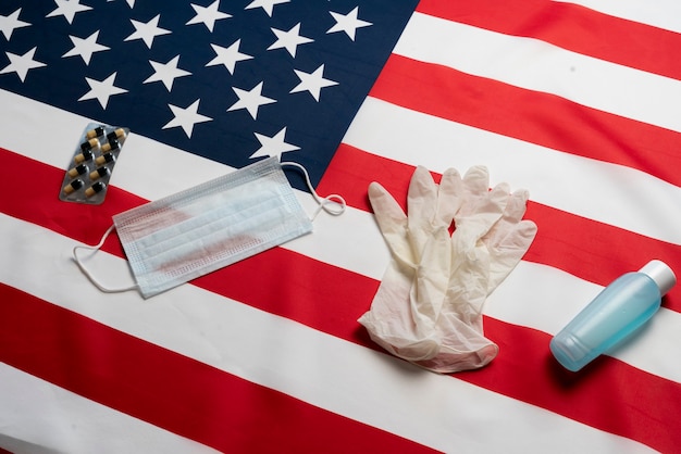 A antiseptic gloves and mask on the american flag as symbol of quarantine and virus protection