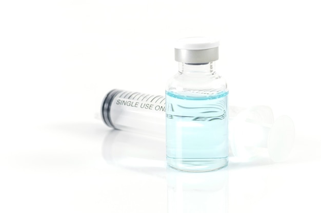 Antivirale vaccinfles en medische spuit op een wit
