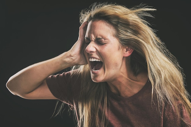 Photo anxiety frustrated and trauma woman crying in dark studio for psychology and mental health mock up depressed bipolar or angry girl shout for depression mental health problem on a black background