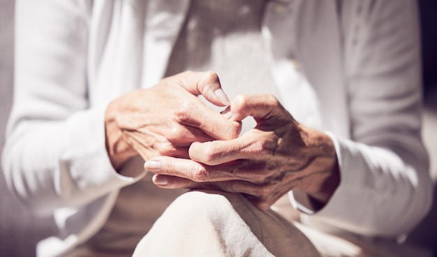 Foto ansia, dolore e mani di una donna anziana in una sessione di terapia per la perdita di salute mentale e supporto consulenza sulla speranza e anziana pensionata in pensione che riceve aiuto presso il centro di riabilitazione psicologica