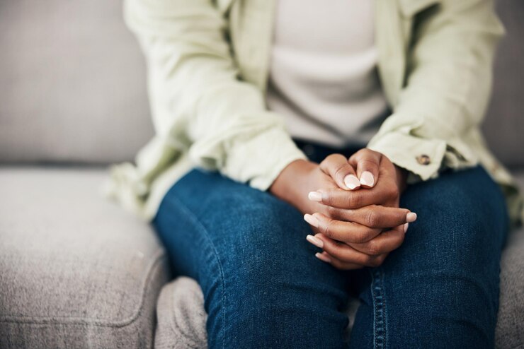Photo anxiety hands and woman on a sofa with stress fear or worry for mental health or domestic abuse in her home psychology zoom and female with depression bipolar or scared of gender based violence