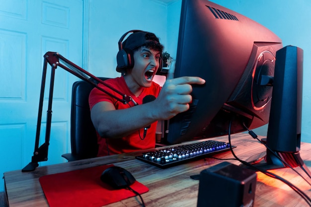 Photo anxious and angry professional gamer man screaming in front of a computer monitor concept mental health