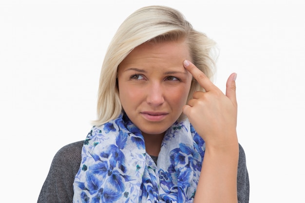 Anxious blonde pointing to forehead