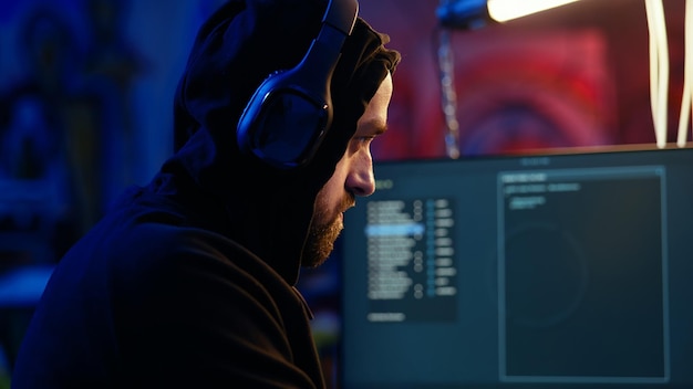 anxious hacker hiding in bunker removing headphones to hear suspicious sounds