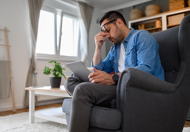 Anxious male computer programmer with headache working on laptop