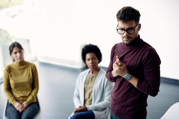 Anxious man talking about his issues during group therapy