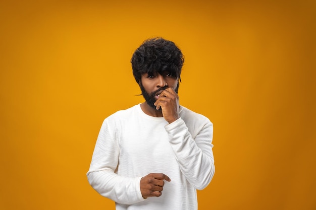 Anxious nervous young black man against yellow background