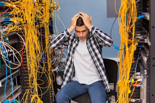 Anxious network engineer sitting on server room