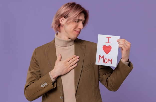 Anxious young handsome man holding and looking at letter for his mom 