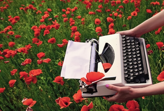 Anzac-dag. Lentebloemen en schrijfmachine met leeg papier op bloesem veld. Herinneren