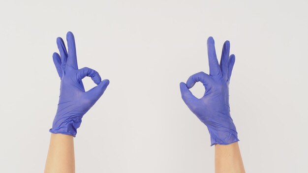 The AOk Hand Sign and 2 hands wear violet or purple latex glove on white background