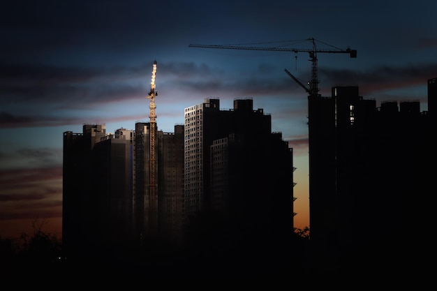 Apartment construction site tower crane red sunset sky and building construction background