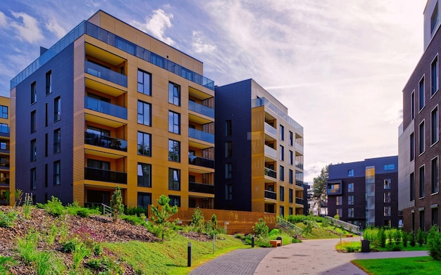 Apartment in residential building exterior. Housing structure at blue modern house of Europe. Rental home in city district on summer. Wall and glass high architecture for business property investment.