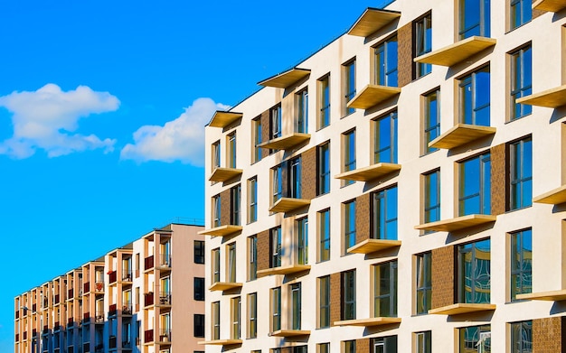 住宅の外観のアパート。ヨーロッパの青いモダンな家の住宅構造。夏の市街地の賃貸住宅。ビジネス不動産投資のための壁とガラスのハイアーキテクチャ。