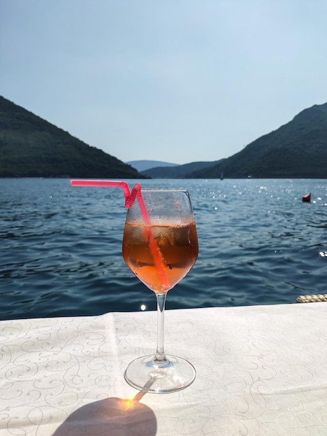 An Aperol cocktail in front of beautiful summer view with the sea and mountains