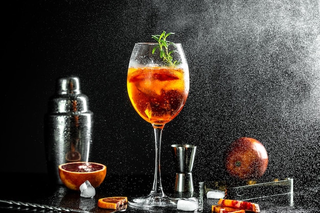Foto aperol spritz aperitief met sinaasappels en ijs met glas bloederige sinaasappels rode bittere droge witte wijn frisdrank schil en ijs op zwarte achtergrond