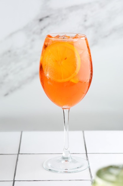 사진 얇게 썬 오렌지와 함께 aperol spritz 근접 촬영입니다. 밝은 배경의 바 카운터에 있는 전통적인 이탈리아 알코올 칵테일 아페롤