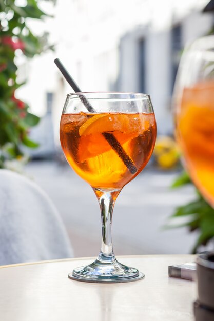 Aperol spritz cocktail, alcoholic beverage based on table with ice cubes