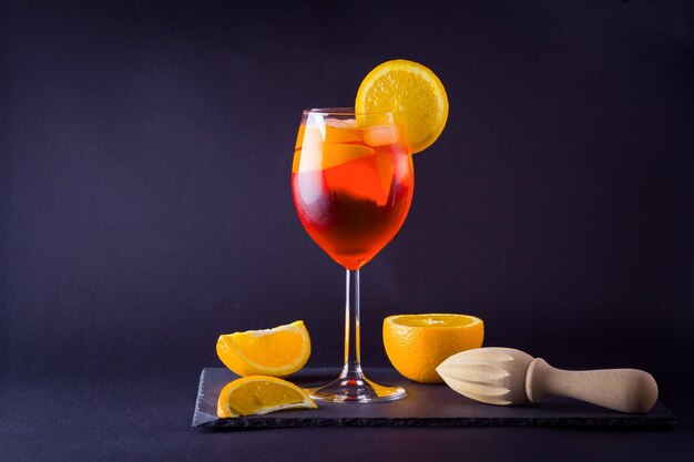 Foto cocktail aperol spritz su sfondo scuro cocktail alcolico estivo con fette di arancia