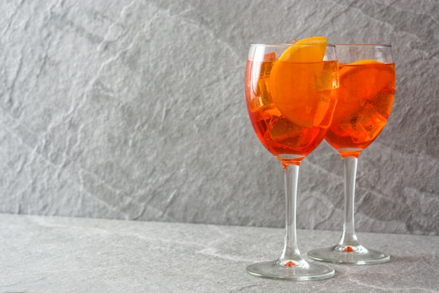 Aperol spritz cocktail in glass on gray stone copy space