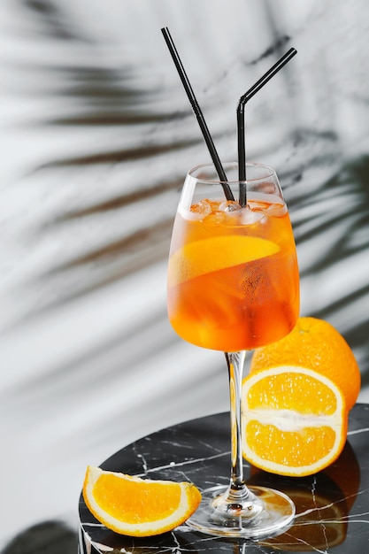 Aperol spritz cocktail in glass and sloced orange on marble table. summer mood concept