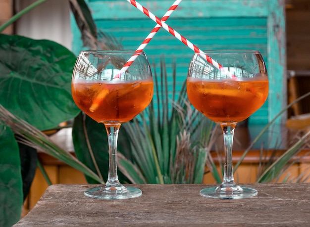 Aperol spritz cocktail oranje twee blauw groene achtergrond ijs bladeren