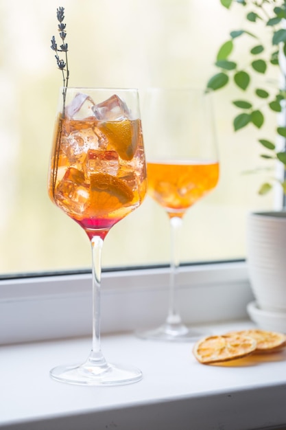 Aperol spritz cocktail with ice in glass on on the windowsill