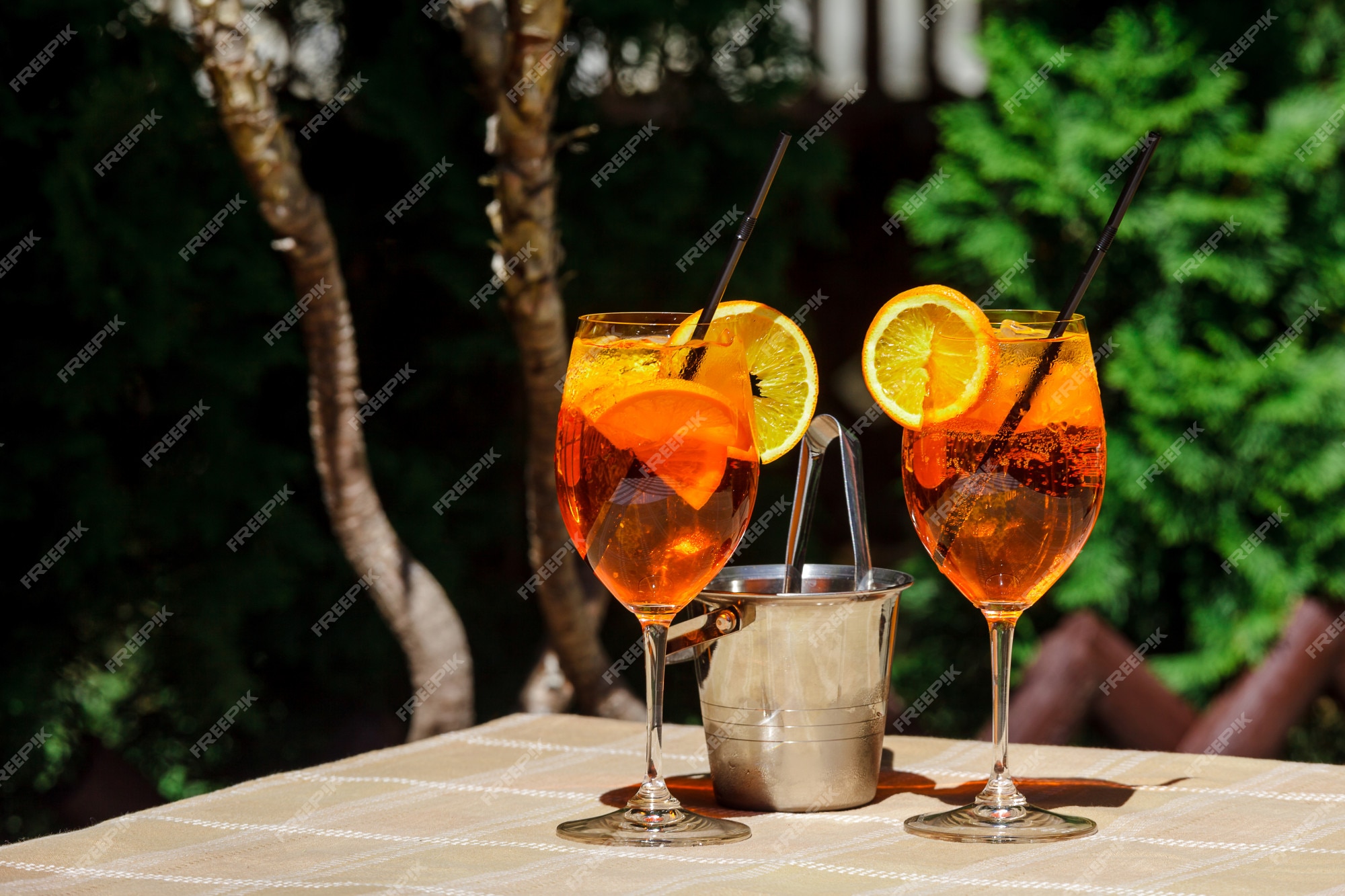 Logisch Gelach Bijdrage Aperol spritz cocktailglas plaid tafel laat zon oranje ijsemmer schaduw  zonlicht | Premium Foto