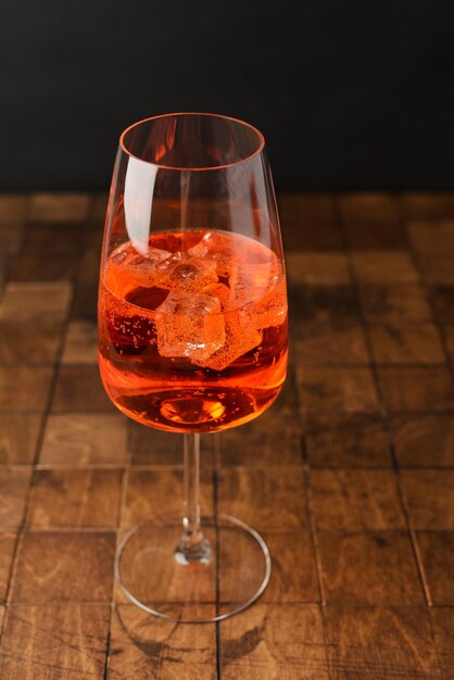 Aperol spritz cold summer cocktail with aperitif prosecco ice and in a glass on the black background Copy space for text