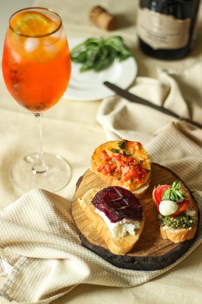 Aperol spritz en natuurlijk voorgerecht van vegetarische bruschetta met groenten, kaas en kruiden