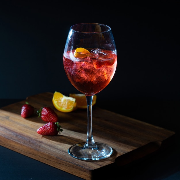 Aperol spritz rode aperitiefcocktail in glas met ijs op zwarte achtergrond